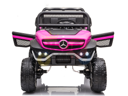 Front view of a Pink 12V/4X4 Official Mercedes Unimog Junior Ride On UTV, resembling a Mercedes-Benz jeep with large wheels, grille guard, and LED lights on a reflective white background—ideal for little adventurers dreaming of their own ride.