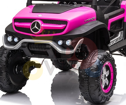 The Pink 12V/4X4 Official Mercedes Unimog Junior Ride On UTV features a silver grille, logo, rugged black tires, and round headlights. Perfect for adventurous kids, it also offers remote control functionality for added fun!.