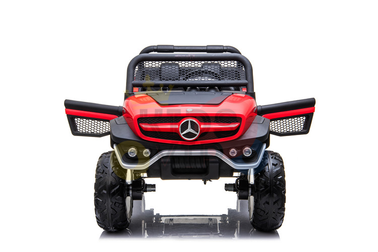 The Red 12V/4X4 Mercedes Unimog Junior Ride On UTV features a remote control, rugged off-road design, red and black color scheme, large tires, and a distinctive grille with circular emblem. Its robust frame boasts intricate mesh details for an authentic look.
