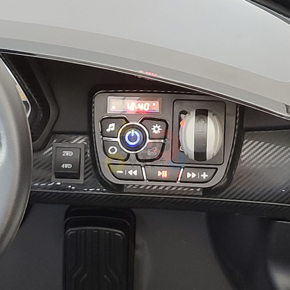 Close-up of the Black 2X12V Limited Edition 4WD Lamborghini Veneno Ride-on Car dashboard, showcasing a digital clock display, light bulb icon knob, music and temperature buttons, plus play/pause and navigation controls—ideal for an elegant 2-seater experience with parental remote control.