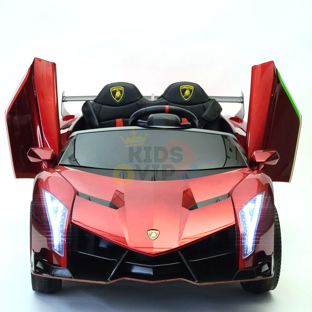 The Red 2X12V Limited Edition 4WD Lamborghini Veneno Ride on Car, RC, has upward-opening doors, black seats with yellow accents, detailed front lights and side mirrors. It’s a limited edition 2-seater with a parental remote control set against a plain white background.