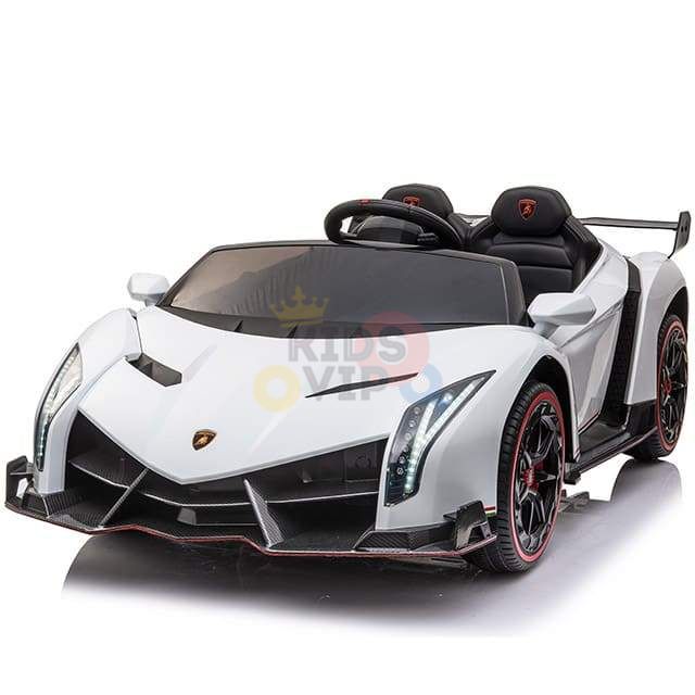 The White 2X12V Limited Edition 4WD Lamborghini Veneno Ride-on Car, RC, features angular headlights, a wide grille, and rear spoiler. This stylish toy has a 2-seater interior with black seats and steering wheel. Black wheels with red detailing complete its sleek design.