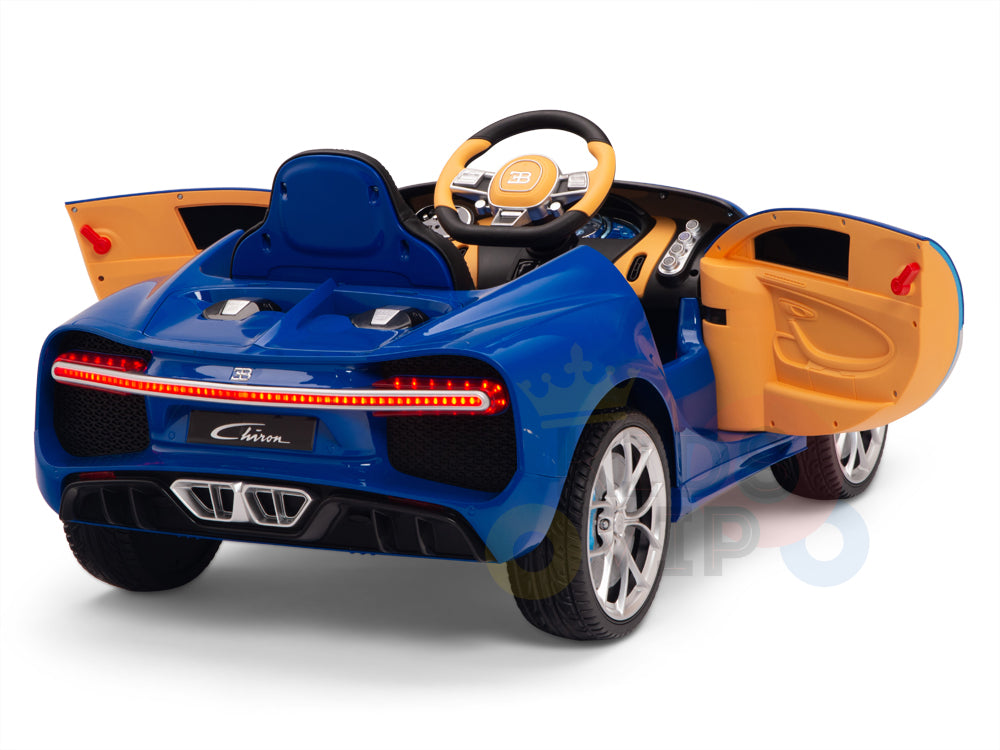 The Blue 12V Bugatti Chiron Kids Licensed 1 Seater Ride On Car features a luxury sports car design with orange interior accents, opening doors, a detailed dashboard and steering wheel, plus red taillights and silver exhaust details. Its rubber wheels ensure smooth rides for young speed enthusiasts.