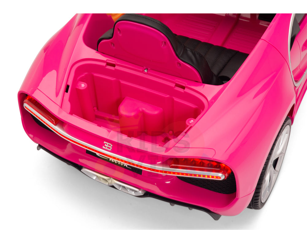 The Pink 12V Bugatti Chiron Kids Licensed 1 Seater Ride On Car boasts a sleek design with rubber wheels, black seat, intricate rear light and bumper details, and an open trunk revealing a simple compartment. Perfect for little racers craving hours of fun!.