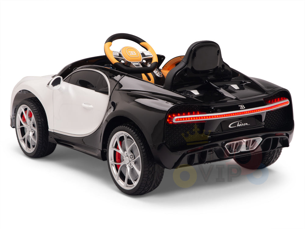 The White 12V Bugatti Chiron Kids Licensed 1-Seater Ride On Car features black and white colors, a detailed interior with a yellow steering wheel, realistic taillights, silver rims, rubber wheels, and remote control. Its sleek aerodynamic design mirrors a luxury sports car.