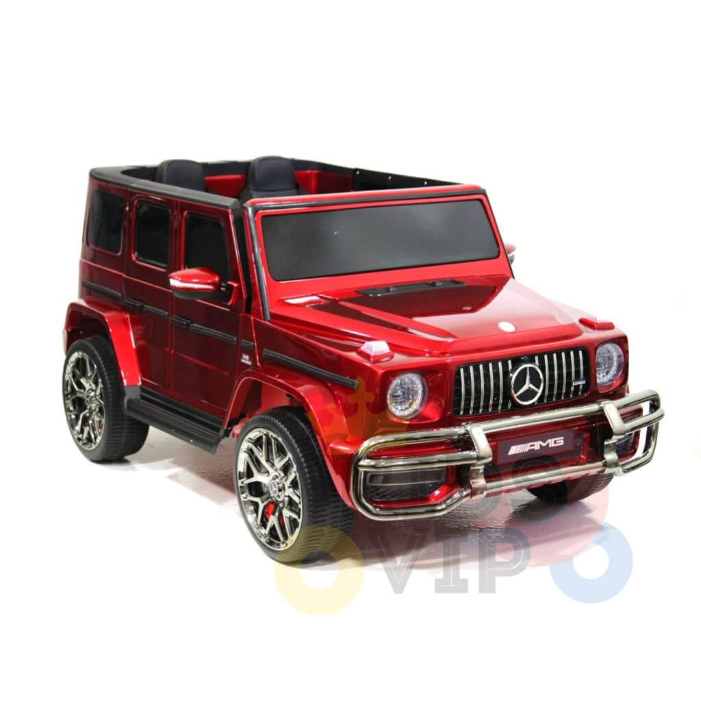 A red toy car resembling the Special LED Edition 2 Seats 4WD 24V Mercedes G Series Ride On features chrome accents, large wheels, a prominent grille and logo, visible black seats, and faded overlapping letters at the bottom of the image.