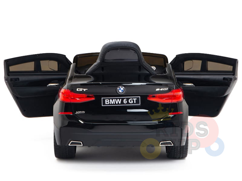 A rear view of the Black Licensed BMW GT 12V Kids Ride On Power Car with doors open highlights its realistic details and BMW 6 GT license plate on a white background, showcasing its upgraded features.