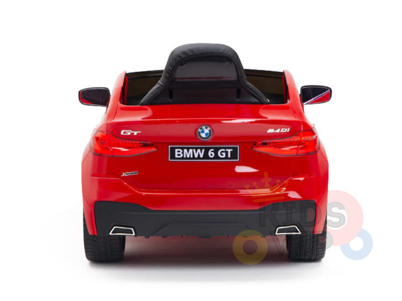 The Red 12V BMW GT Kids Licensed Ride On Car, a realistic one-seater with rubber wheels and remote control, features rear taillights and dual exhaust design with visible brand and model logos, capturing the essence of a full-sized vehicle.