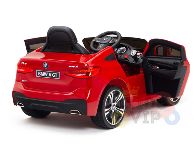 The Red 12V BMW GT Kids Licensed 1 Seater Ride-On Car features open doors, a black seat, and steering wheel like a real BMW 6 GT. It includes realistic gauges on the dashboard and BMW 6 GT on the rear, set against an elegant white background.