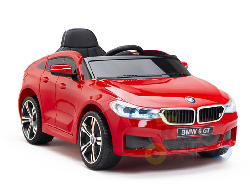 This sleek red 12V BMW GT Kids Licensed Ride On Car features realistic details like headlights, a black windshield, and alloy-style wheels. This licensed toy stands out against a white background and includes rubber wheels with a remote control.