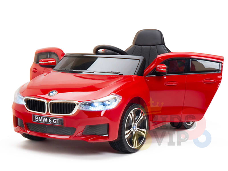 This licensed 12V red BMW GT kids ride-on car features black seats, open doors, glowing headlights, detailed rims, and the BMW logo with BMW 6 GT on the license plate for a realistic design.
