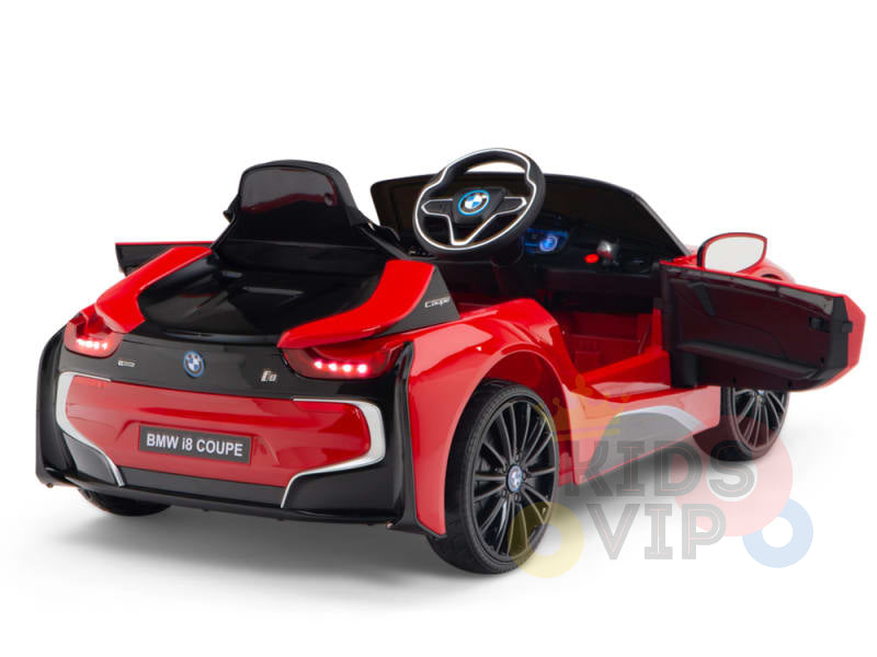 The Red Licensed Sport BMW I8 12V Kids Ride On Power Car features scissor doors, a visible steering wheel, detailed rims, and rear lights. It offers both fun and safety with parental remote control. The background is plain white.
