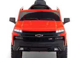 Introducing the Red 12V Chevrolet Silverado Kids Licensed 1 Seater Ride On Truck with Music and Remote: a ride-on car styled like a red pickup truck featuring a black grille, LED headlights, large wheels, steering wheel, detailed interior, and remote control for extra fun.