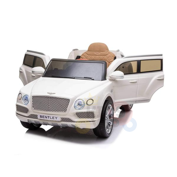The White 12V Bentley Bentayga Kids Licensed 1 Seater Ride On Car features tan seating, detailed headlights, chrome wheels, and open doors. Children can enjoy driving this mini Bentley with a remote for extra fun.