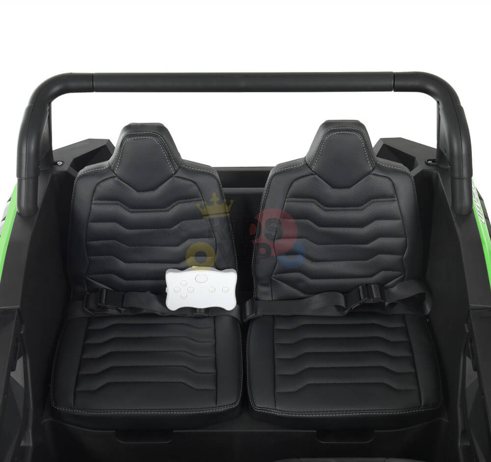 The 2 Seater XXL Blade BT 4WD Edition features two black leather-like seats with seat belts for an off-road adventure. A white toy steering wheel on the left is framed by striking black and green elements, all powered by the robust 24V Blade BT system.