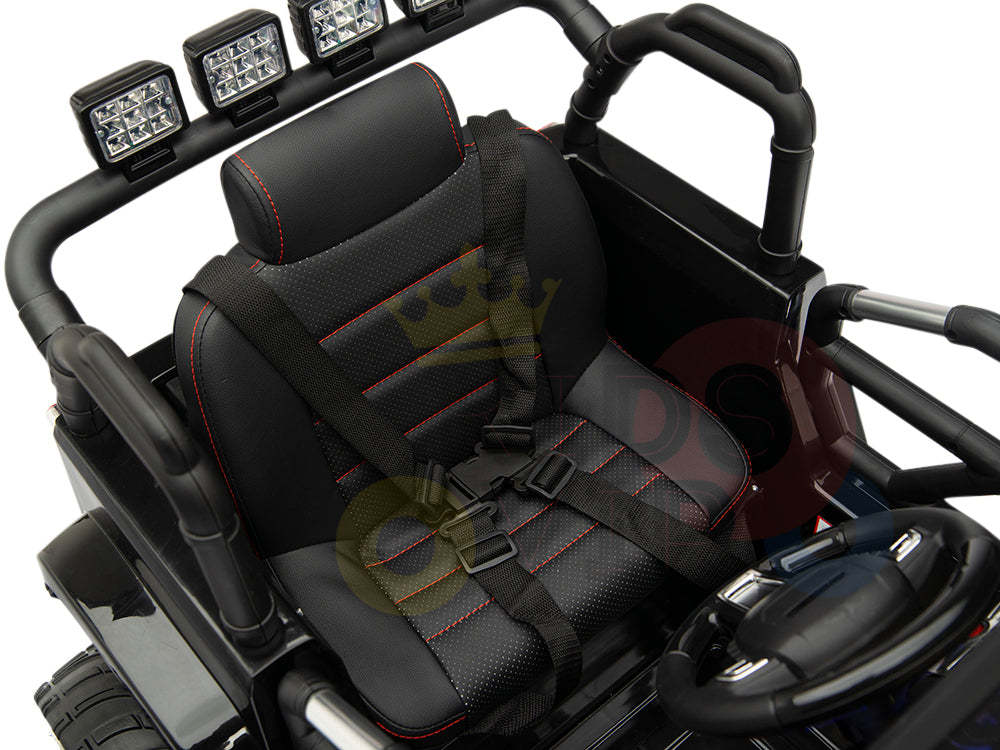 The image highlights the upgraded features of the 4X4 Big Wheels EVA Edition 12v Kids Ride on Truck, including a black toy car seat with red stitching, visible safety harness, and three square LED lights mounted on the roll bar. The sleek design includes a steering wheel on the right side.