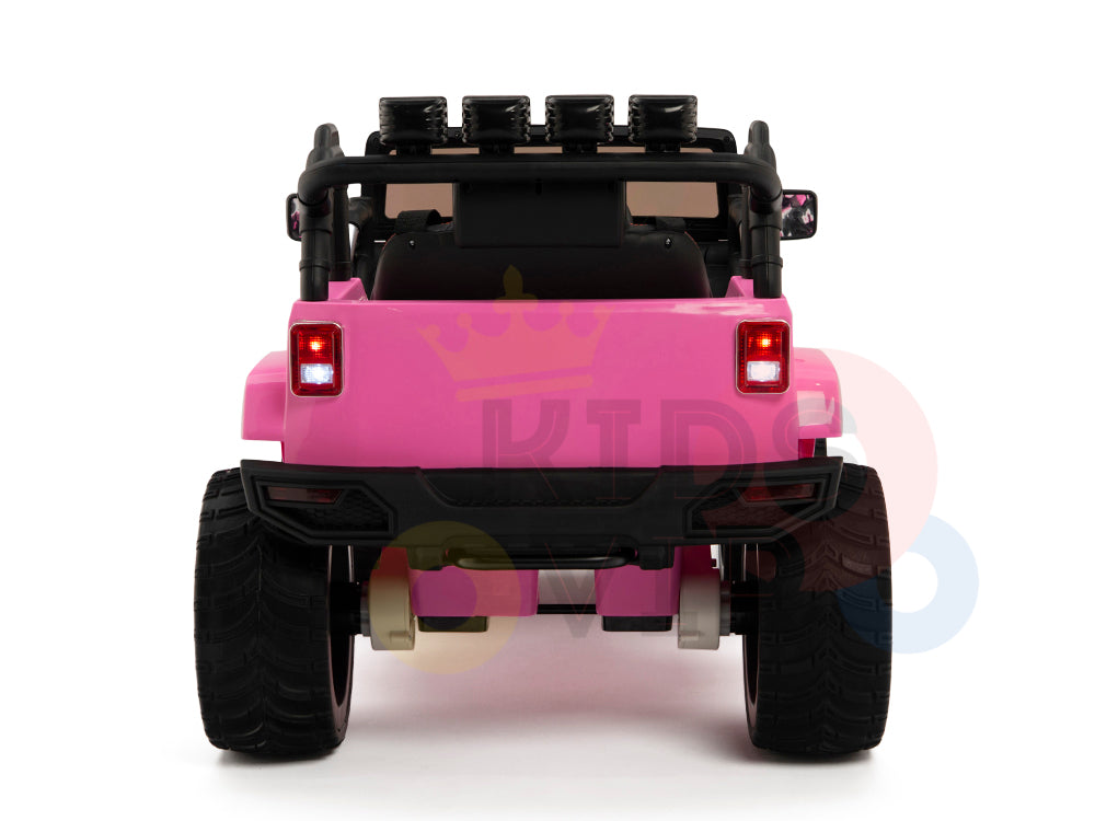 The image shows the rear of a pink 4X4 Big Wheels EVA Edition 12v Kids and Toddlers Ride on Truck with RC. It has large black tires, a roll bar with spotlights, and illuminated brake lights against a white background, suggesting safe adventures thanks to its parental remote control feature.
