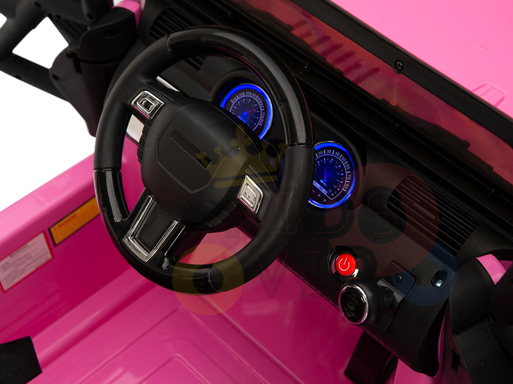 The image displays the interior of the 4X4 Big Wheels EVA Edition 12v Kids and Toddlers Ride on Truck with RC, showcasing the pink toys steering wheel, dashboard, and illuminated blue speedometers. This truck ensures fun and safety with its power button, controls, and parental remote control option.
