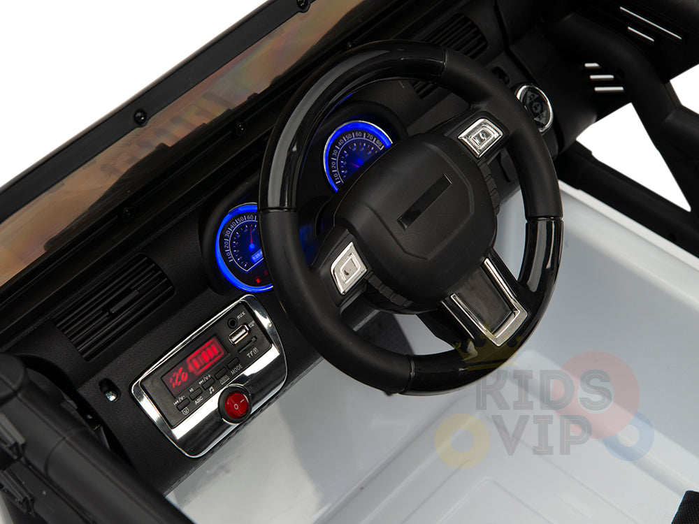 The dashboard of the 4X4 Big Wheels EVA Edition 12v Kids and Toddlers Ride on Truck with RC showcases a steering wheel, blue-lit speedometers, and a digital display reading 12.0 CDN. Its black interior with silver and chrome accents reflects the toys sophisticated design.