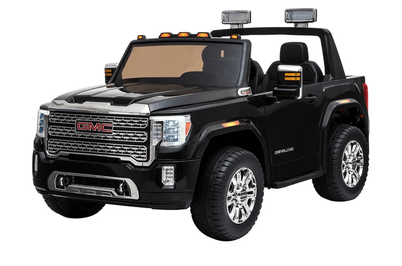 This toy ride-on car is a mini GMC Sierra, featuring eco leather seats and chrome details. Large wheels, realistic headlights, an open top, and side mirrors enhance its authentic appearance.