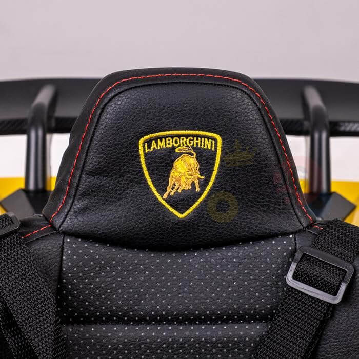 Close-up of a black leather seat in the Yellow Officially Licensed 12V Lamborghini Huracan Sports Edition Ride on Car with a bull logo embroidered in yellow and striking red stitching on the headrest.
