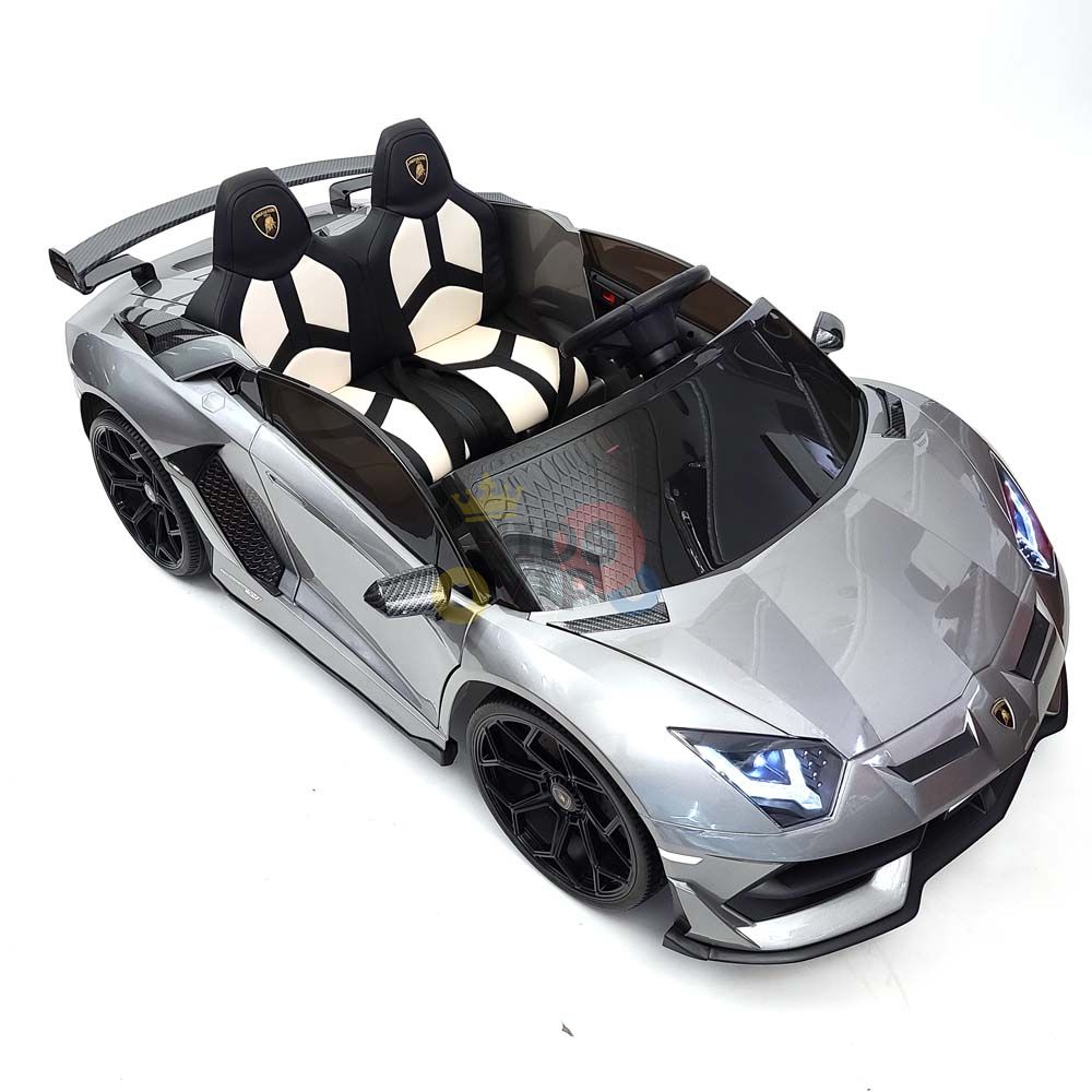 The Upgrade Your Ride: Experience the Thrill of Drifting with the Complete Edition 24V Lamborghini Sport Car in metallic silver boasts black and white seats, a convertible design, blue headlights, and sporty detailing. Ideal for young car enthusiasts, it includes a KidsVip Warranty and is set on a plain white background.