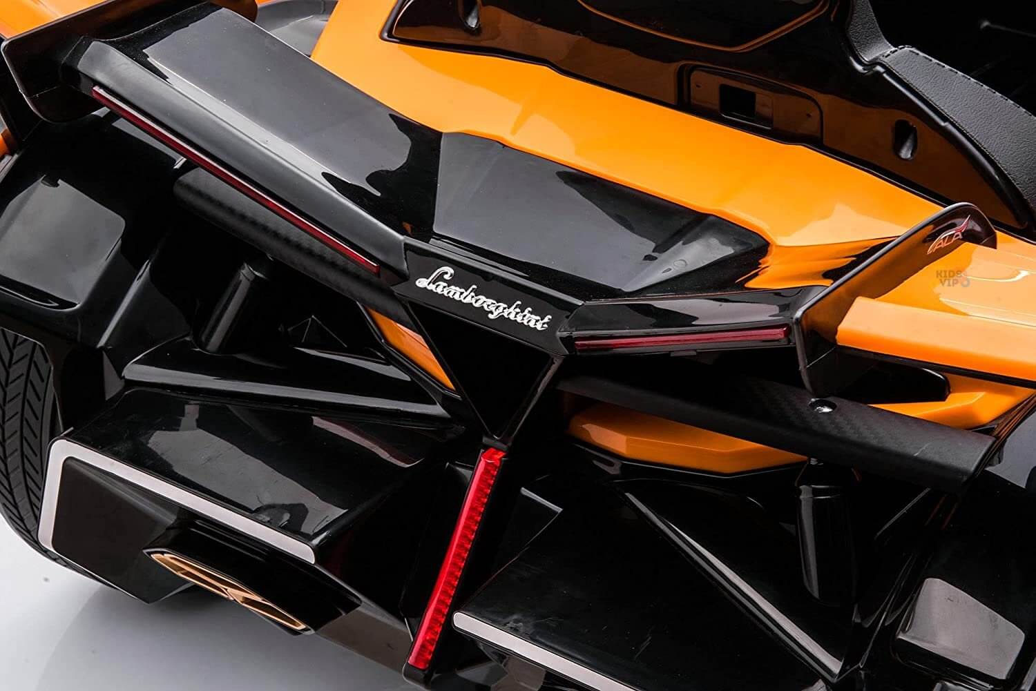Close-up of the rear section of an Orange 12V Official Lamborghini Vision GT Kids Ride on Car, showcasing sleek, angular design similar to a Lamborghini Vision GT with red accents. Prominent branding near the top center highlights its striking style.