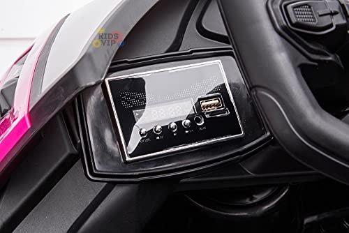 Close-up of the Pink 12V Official Lamborghini Vision GT Kids Ride-on Car dashboard, featuring a sleek style with a small display, four buttons, an AUX input, and a USB port on the predominantly black dash with hints of pink.