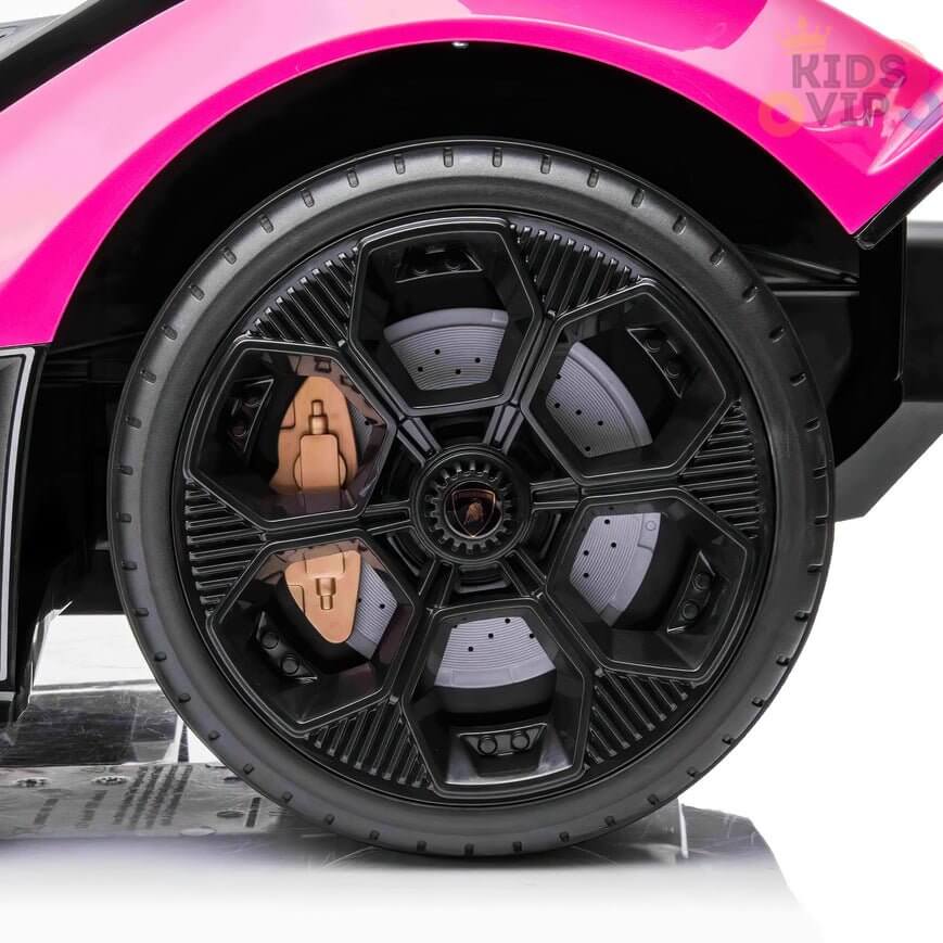 The image showcases a close-up of a car wheel with sleek, angular black rims, part of the Pink 12V Official Lamborghini Vision GT Kids Ride-On Car. The brand KIDS VIP is partially visible in the top right corner.