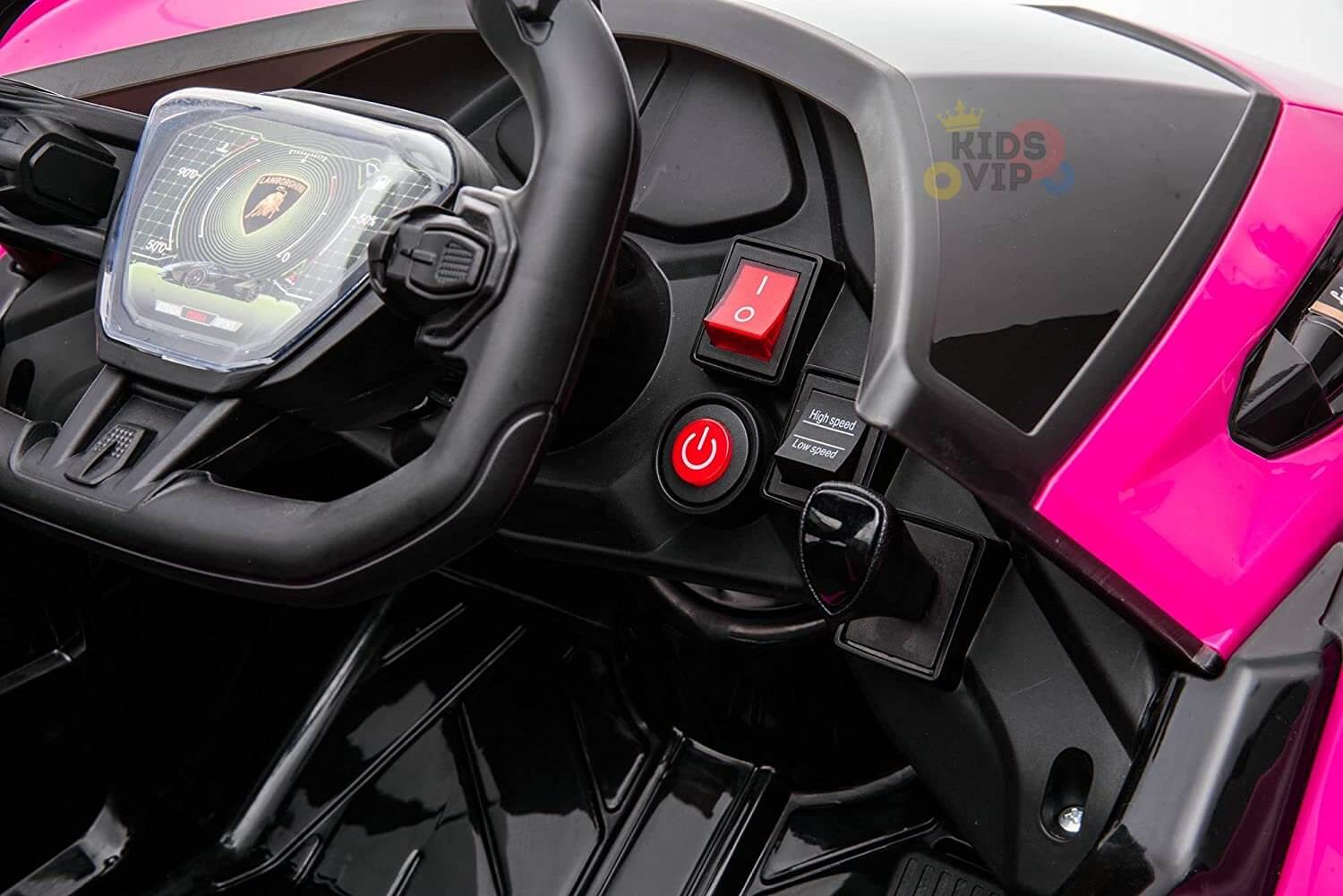 Close-up of the Pink 12V Official Lamborghini Vision GT Kids Ride-On Car dashboard, featuring a steering wheel, digital display mimicking a luxury logo, power button, and various controls in a sleek black and pink interior.