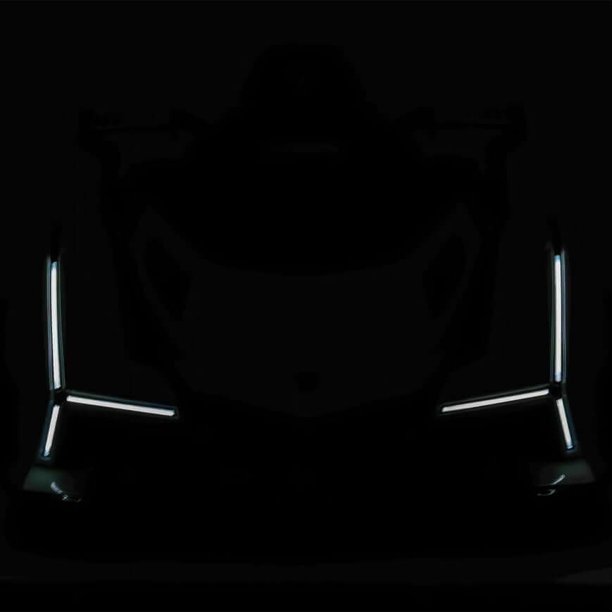 A dark image of the Green 12V Official Lamborghini Vision GT Kids Ride on Car, featuring sharply lit LED lights outlining its front, exudes a futuristic and mysterious vibe.