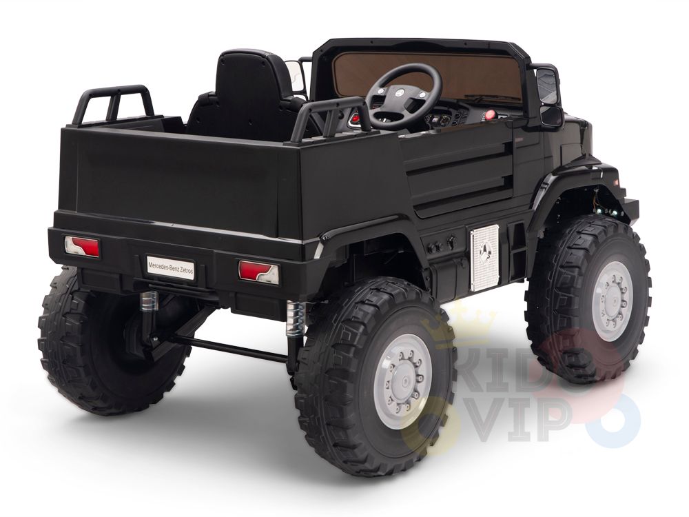 The Black 12V Mercedes Benz Zetros Kids 1 Seater Ride On Truck features oversized rubber wheels, a detailed dashboard, and rear cargo area. Its perfect for adventurous play, offering a thrilling ride from the back view with its miniaturized design and exciting functionalities.