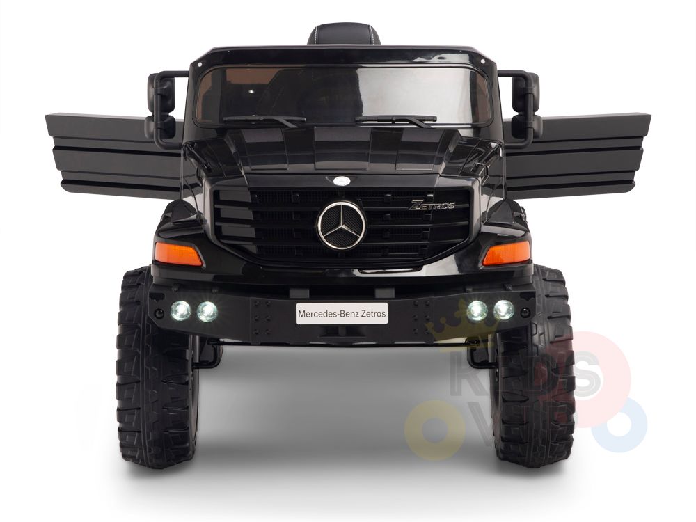 The Black 12V Mercedes Benz Zetros Kids 1 Seater Ride On Truck features rubber wheels, a detailed front grille, and realistic headlights. Its opening doors reveal branding for adventurous playtimes, making it the perfect ride-on car for children.