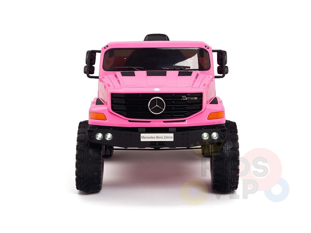 The Pink 12V Mercedes Benz Zetros Kids 1 Seater Ride On Truck stands boldly on a white background with large black rubber wheels and a detailed front grille featuring the iconic logo, promising endless fun even with headlights off, its vibrant charm shines through.