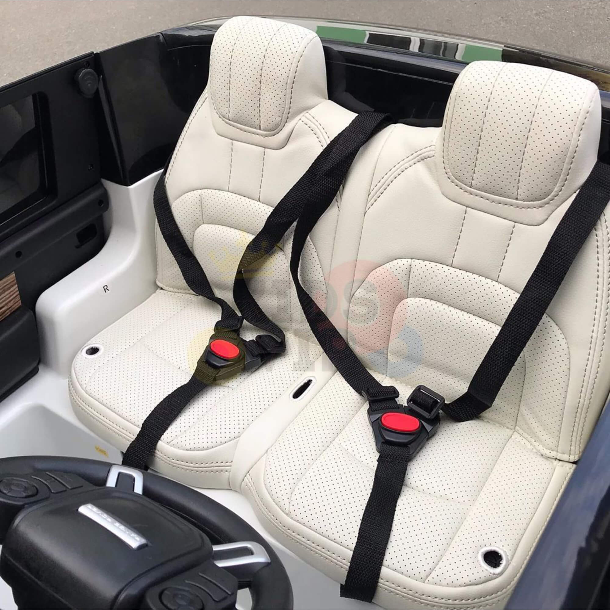 The licensed 24V White on White Range Rover toy car includes two white leather-like seats with black seatbelts, a steering wheel and control panel on the dashboard, and a colorful logo on the backrest, highlighting advanced ride-on technology.