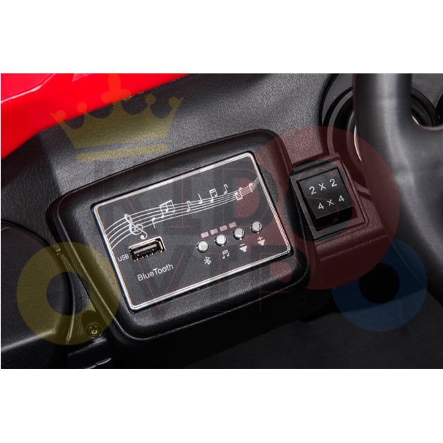 A close-up of the Upgraded 12V Junior Sport Utility Ride On Buggy/UTV 4WD Edition panel shows music note graphics, a Bluetooth USB port, indicator lights, and a 2 x 2 or 4 x 4 switch. Its bold red and black design enhances this junior ride on.