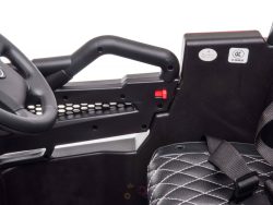 Close-up of the Upgraded 12V Junior Sport Utility Ride On Buggys interior, showcasing a black steering wheel with branding, black seat with white stitching, safety belt, and side handlebar with red button.
