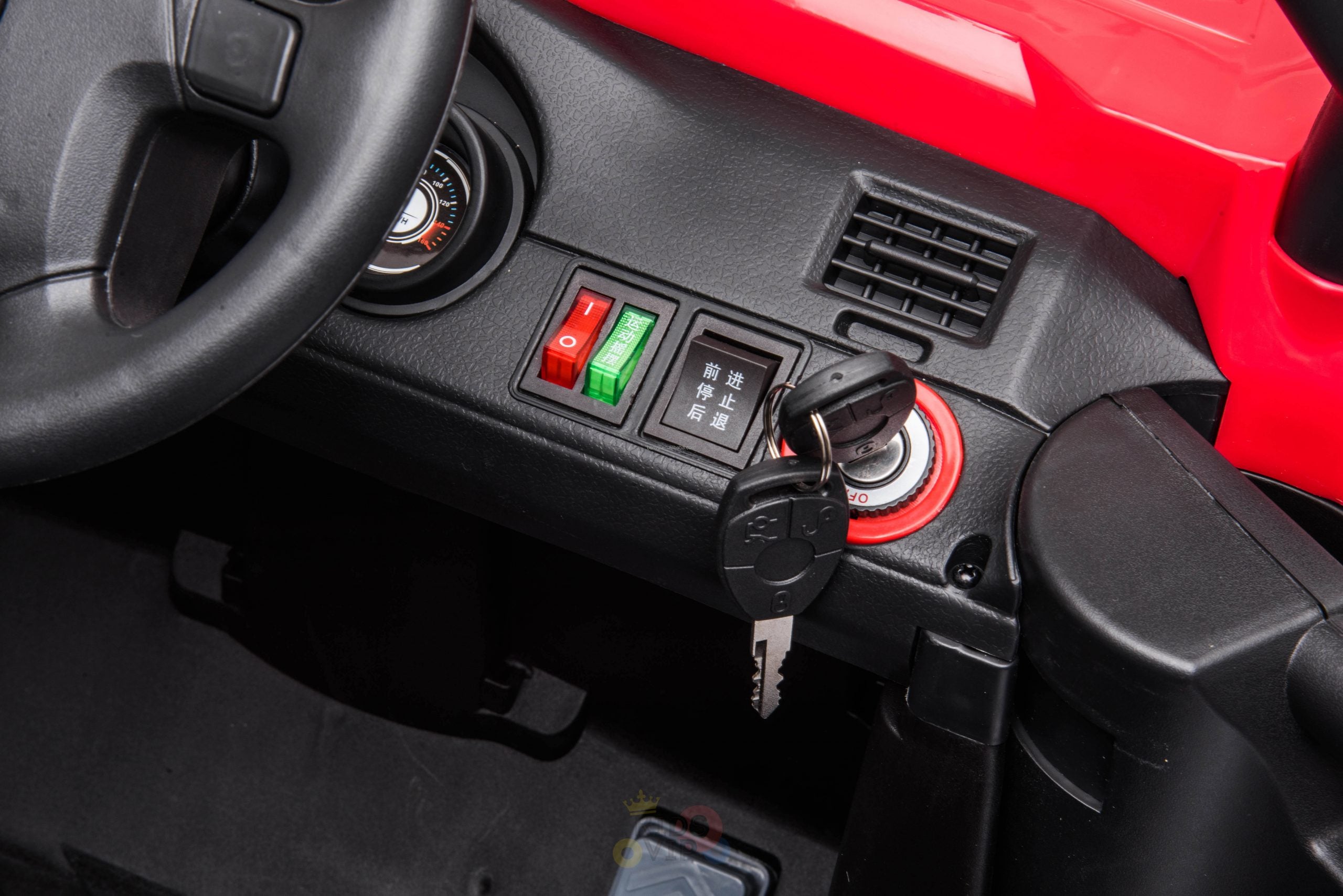 A close-up of the Upgraded 12V Junior Sport Utility Ride On Buggy/UTV 4WD dashboard reveals a steering wheel, ignition key, and various controls. It includes green and red switches with black inscriptions in a foreign language, perfect for enthusiasts of the Junior Sport Utility Ride On experience.