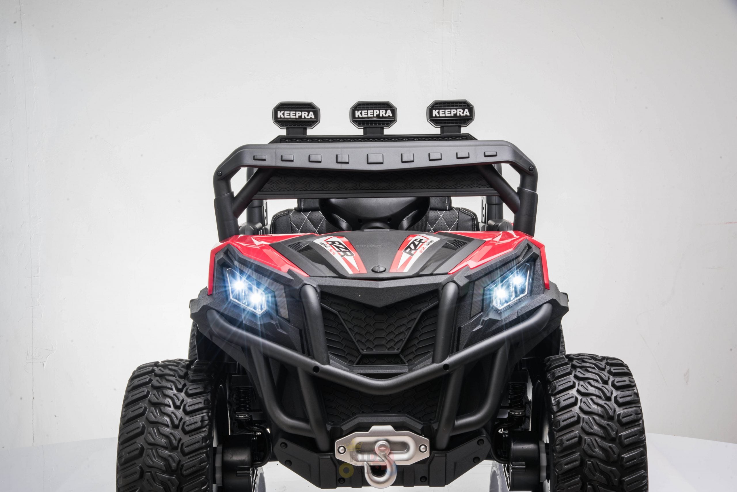 The Upgraded 12V Junior Sport Utility Ride On Buggy/UTV 4WD Edition features LED headlights, a protective grille, and KEEPRA labeled spotlights against a white background.