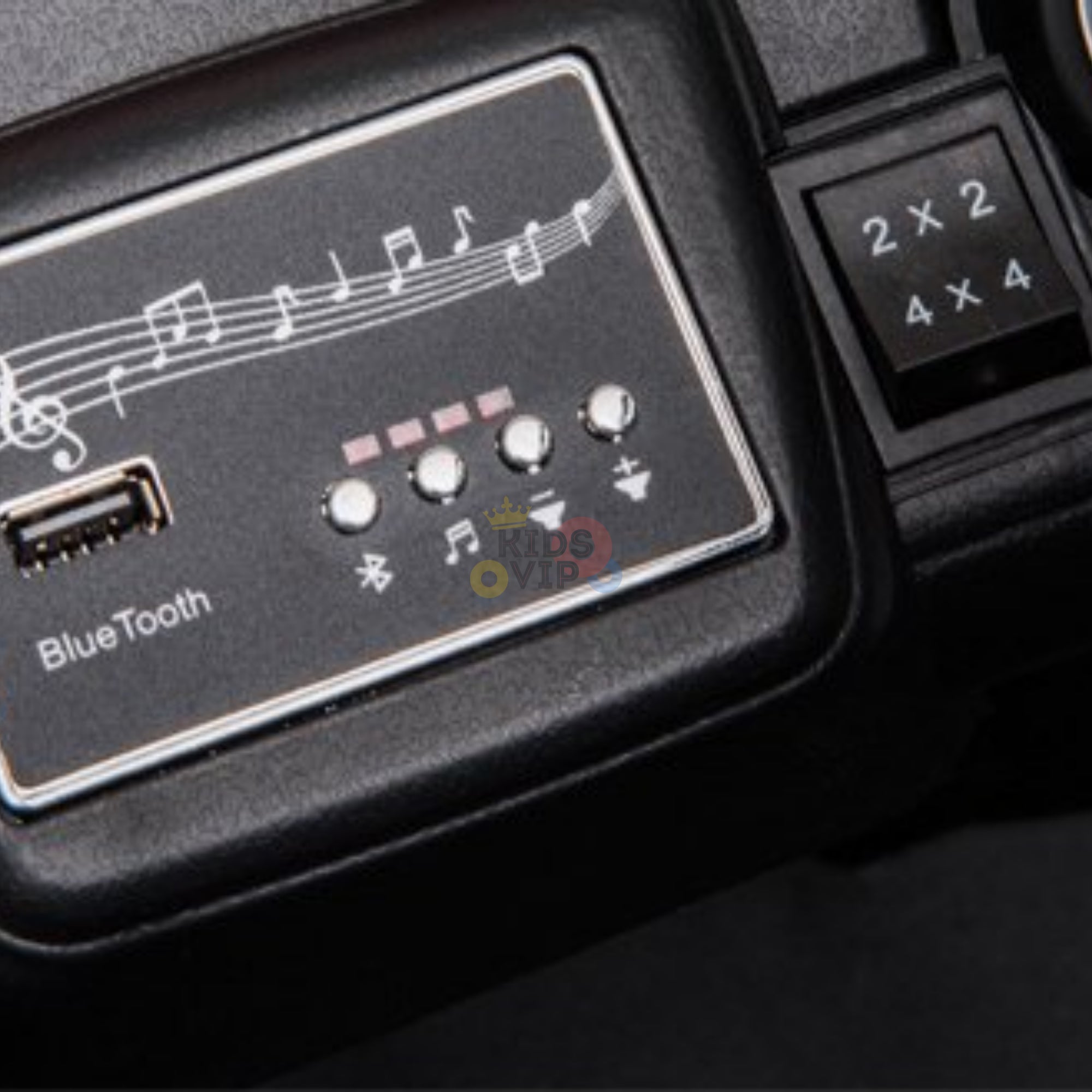 Close-up of a Bluetooth audio panel with a music note design, USB port, buttons, and Bluetooth symbol on the Upgraded 12V Junior Sport Utility Ride On Buggy/UTV 4WD Edition. A number panel shows 2x2 above 4x4 on its sleek black surface, perfect for your ride-on buggy.